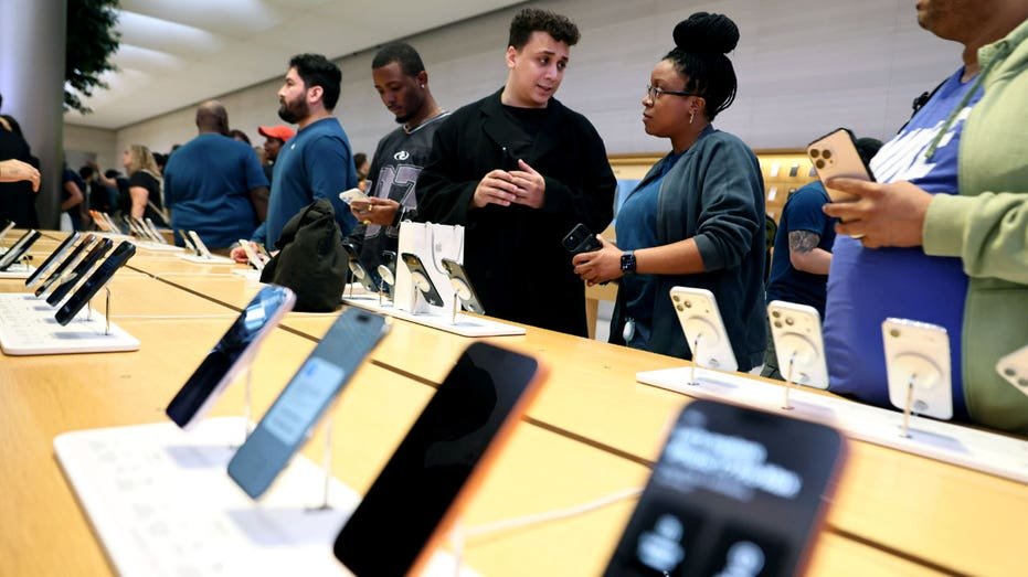 People shop for Apple iPhones in a store.