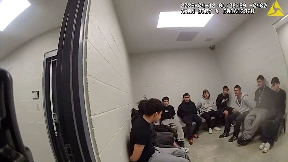 Police officers taking individuals into custody at an intersection in Atlanta