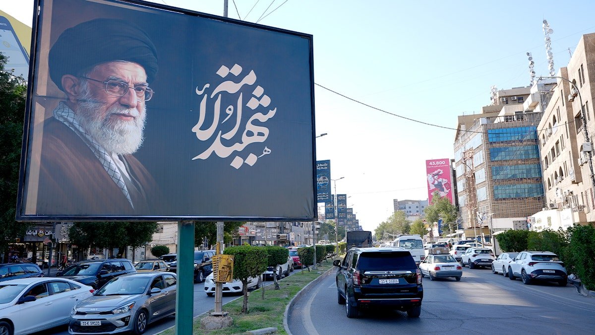 A billboard featuring a photo of Ali Khamenei along a street in Baghdad