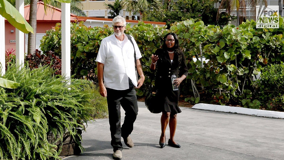 Brian Hooker walking out of a hotel in The Bahamas with his lawyer