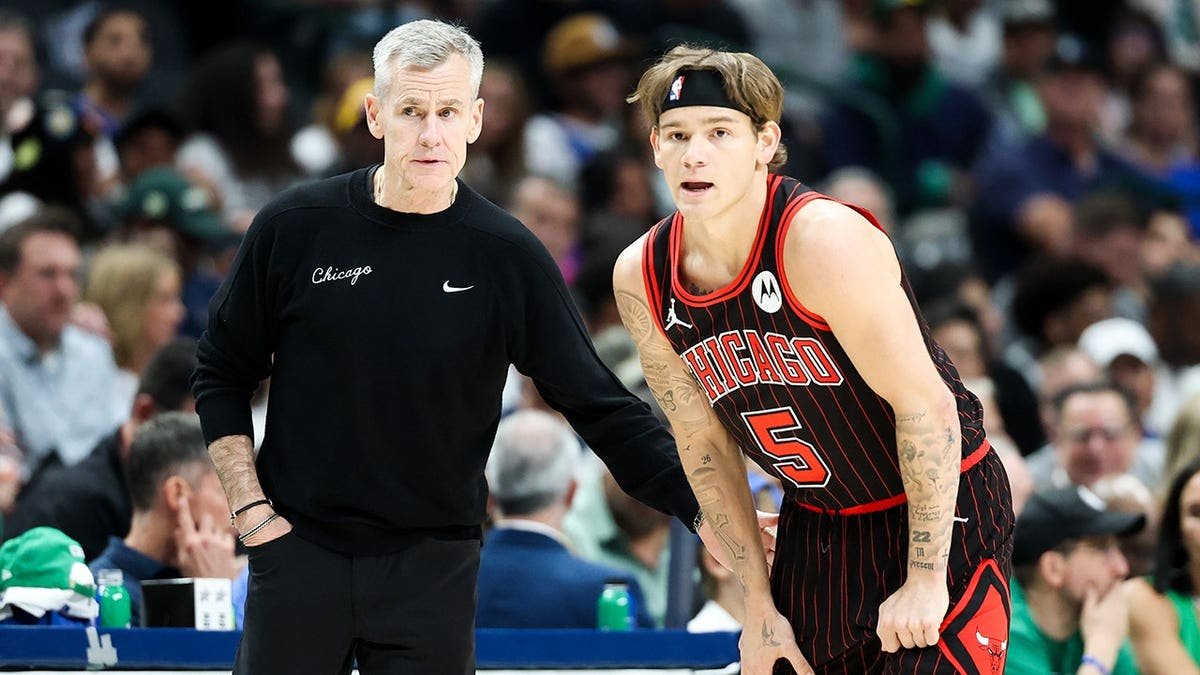 Chicago Bulls head coach Billy Donovan speaking with guard Mac McClung on basketball court
