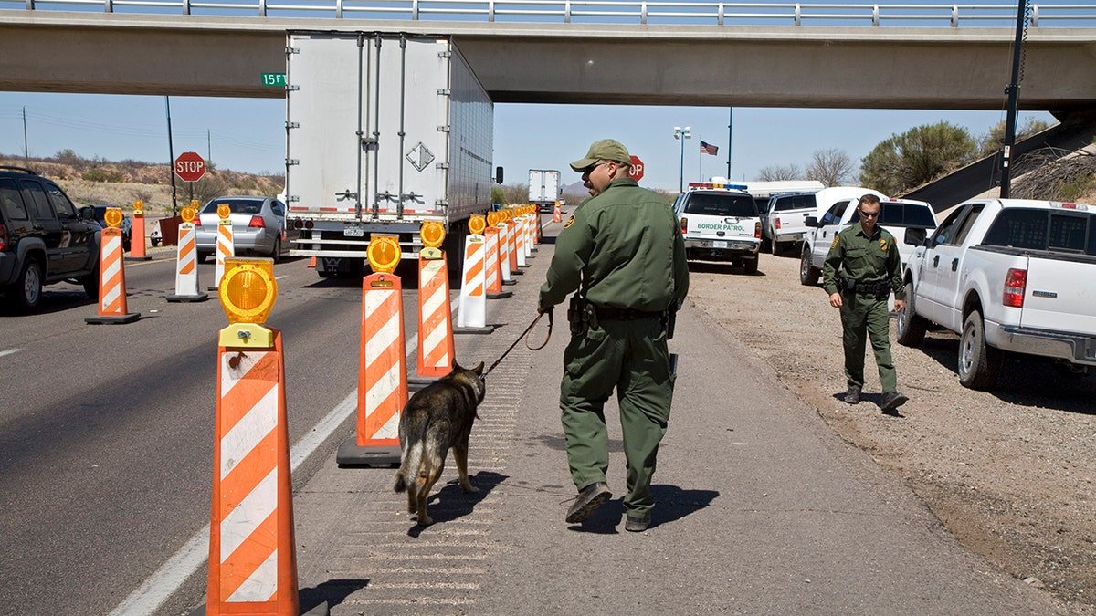 Border Patrol agents inspecting vehicles at checkpoint on Interstate 19 in Tubac, Arizona