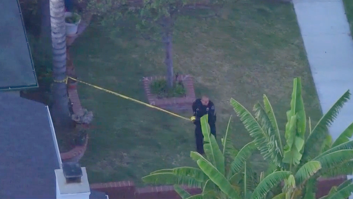 Police officer at taped-off crime scene in Burbank neighborhood after deadly stabbing
