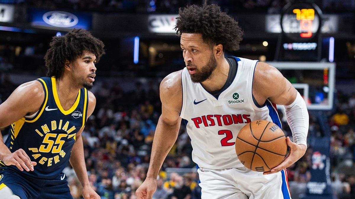 Detroit Pistons guard Cade Cunningham dribbling basketball defended by Indiana Pacers guard Ethan Thompson