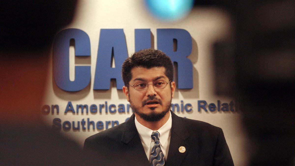 Hussam Ayloush in suit speaking