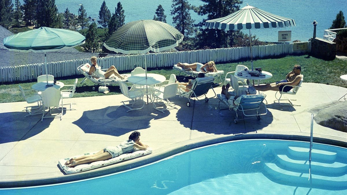 Guests relaxing at a swimming pool at Cal Neva Lodge on Lake Tahoe shore