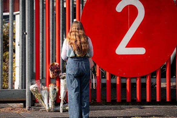 Supanova stallholder Malika Carper leaves flowers at the gate where the men were hit by a car.