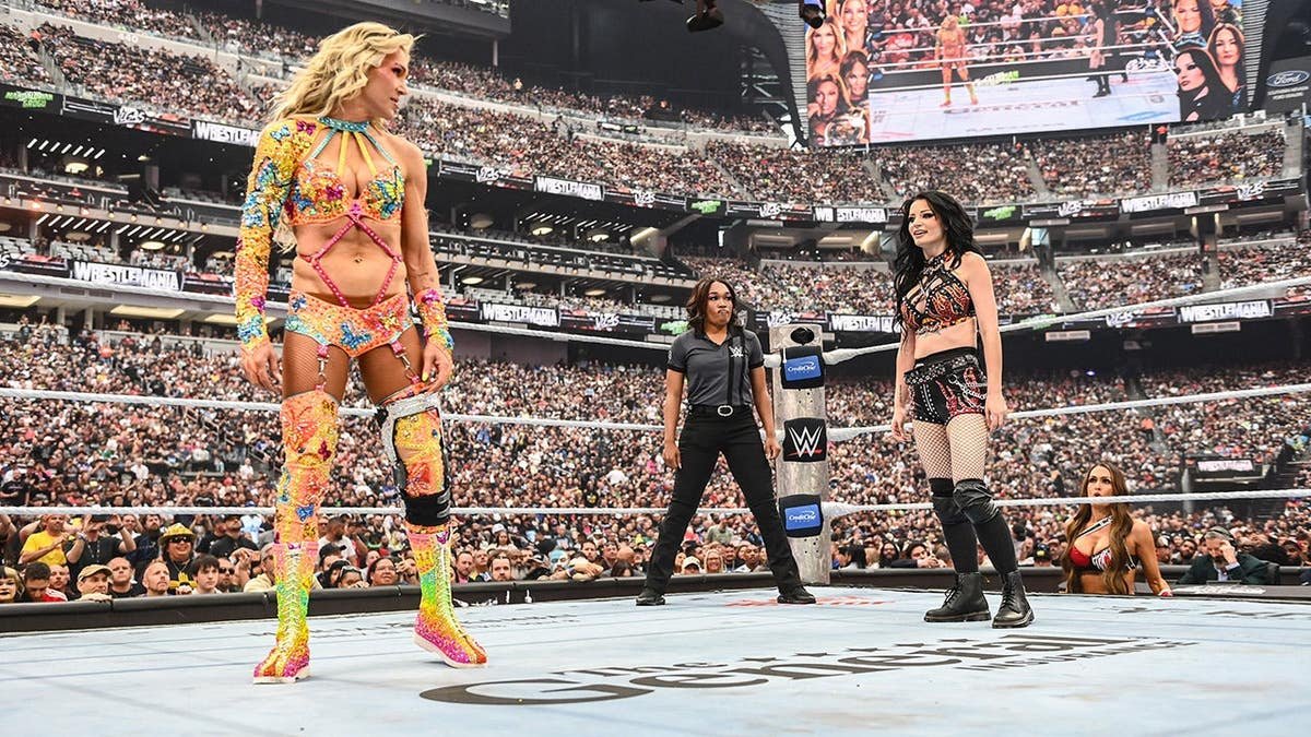 Charlotte Flair faces off with Paige in a wrestling ring at Allegiant Stadium
