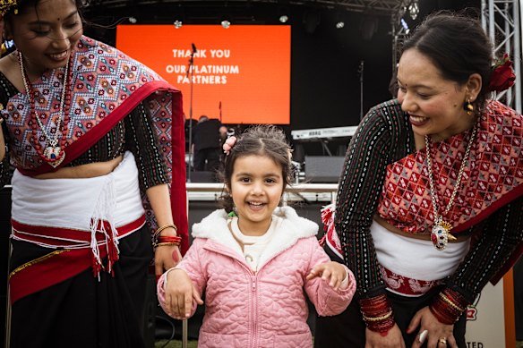 Having fun: Sehar Singh, 4, with Nepalese dancers at the Momo Fest in Footscray.