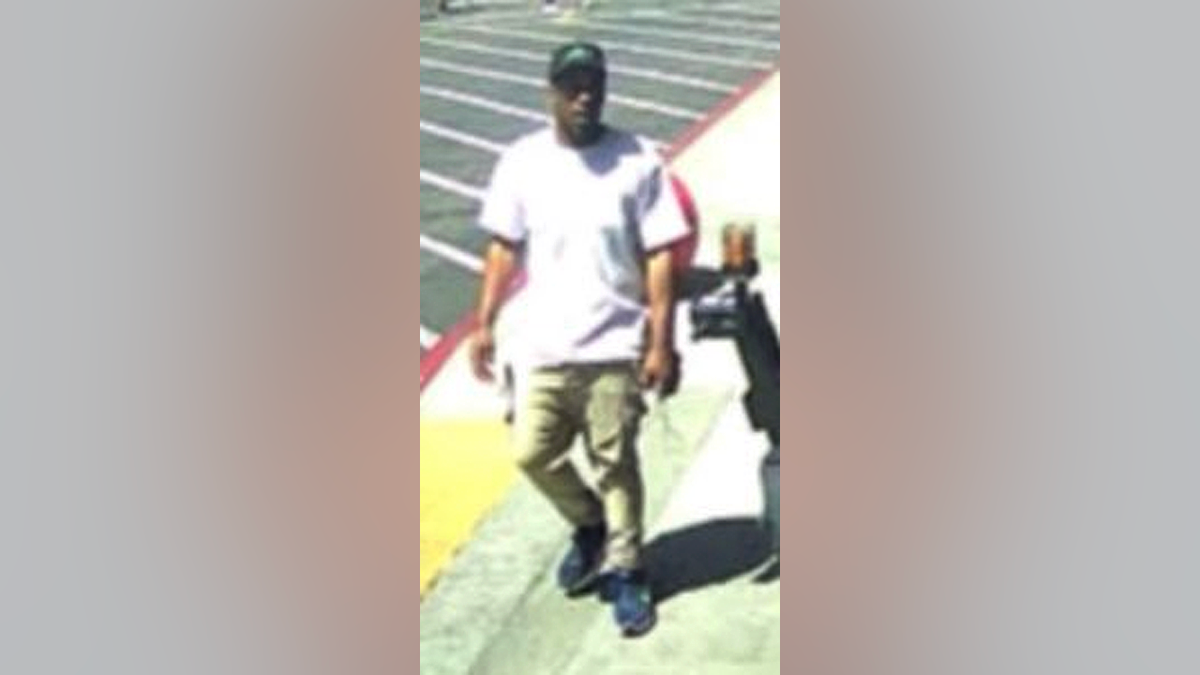 Surveillance image of suspect Damian Denzell Robinson walking in a parking lot in Los Angeles