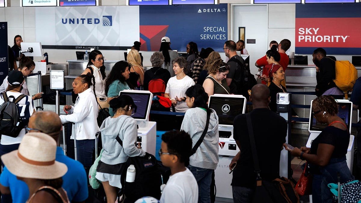Travelers waiting in line at a Delta Airlines counter at Ronald Reagan National Airport