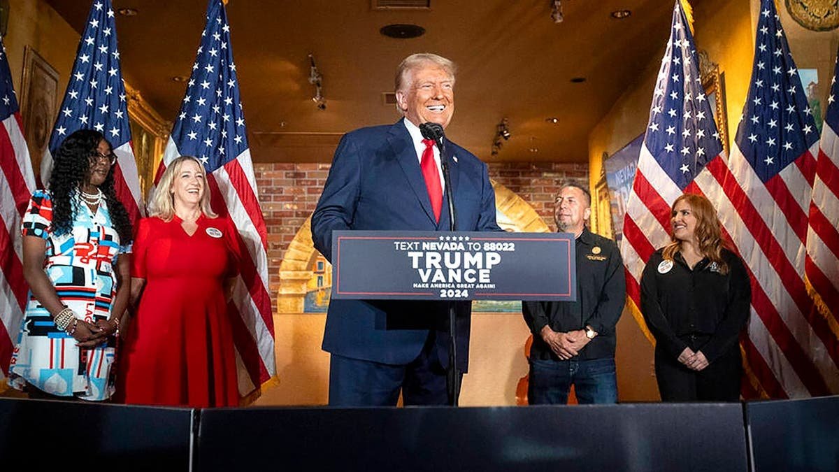 Trump smiles at podium during No Tax on Tips campaign event.