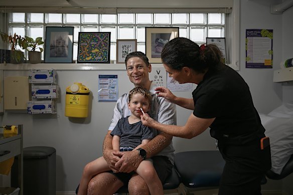 Dr Annalyse Crane gives three-year-old Hamish Gray his first nasal spray flu vaccine at Family Medical Practice in Kirrawee, alongside his father, Ben. 