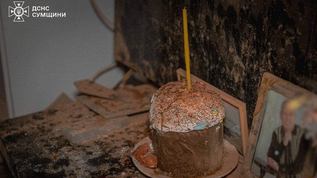 An Easter bread with a candle covered by dust inside a damaged apartment in Sumy
