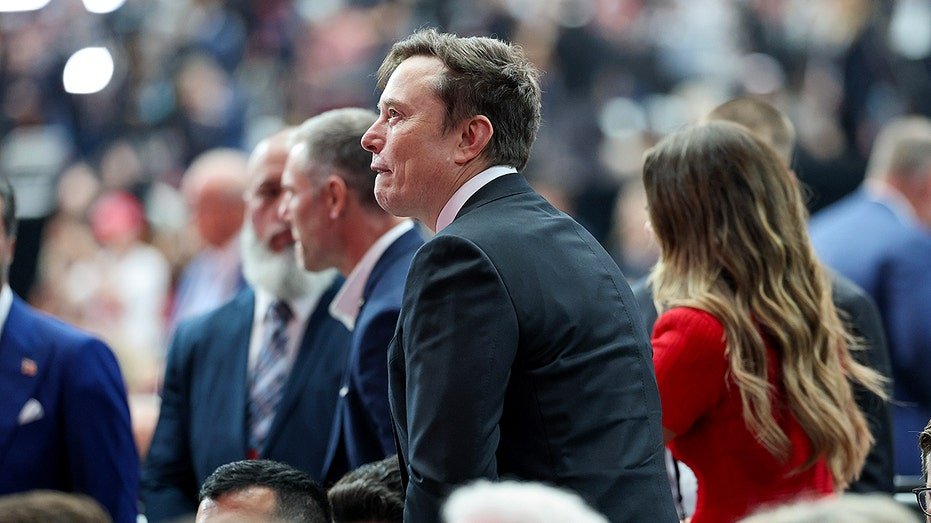 Elon Musk surrounded by people