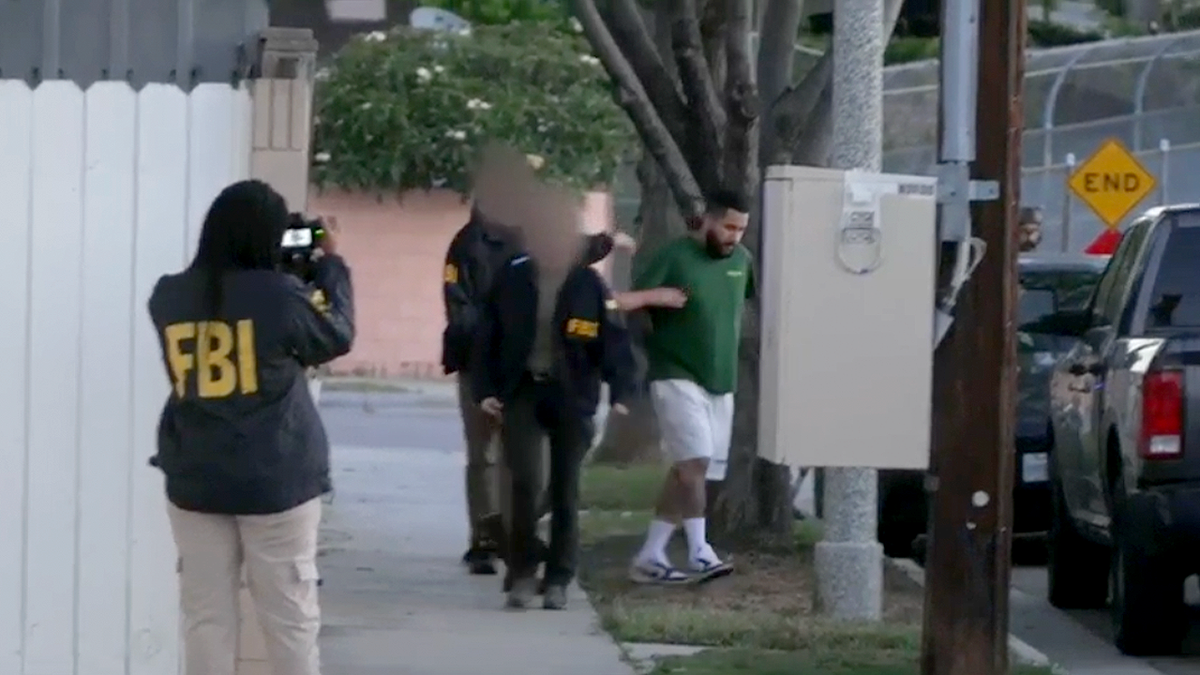FBI agents escort suspected Mexican Mafia member during early morning arrest in Orange County