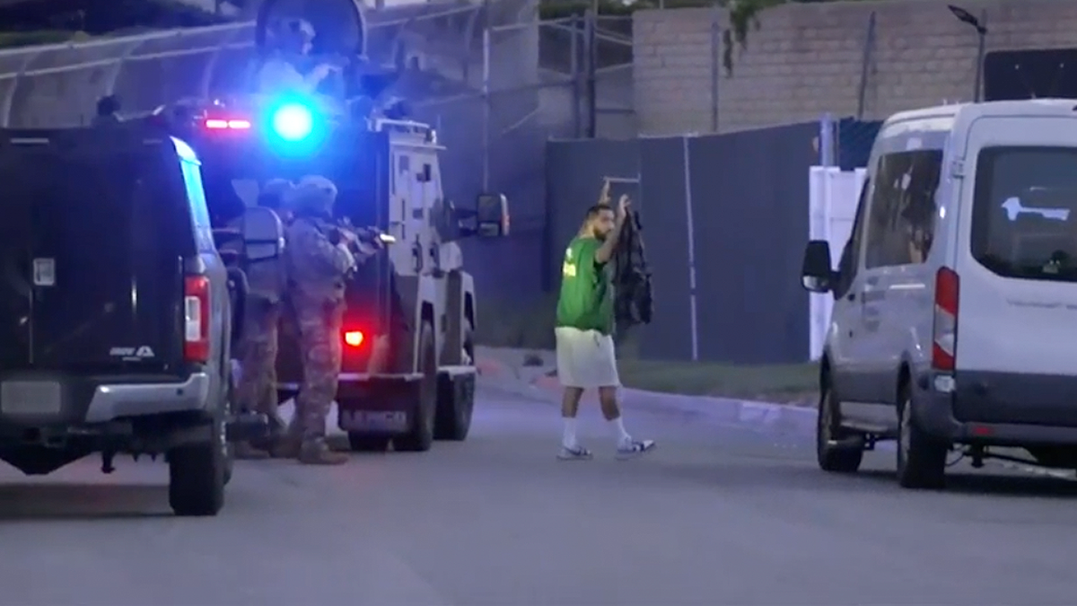 Armed federal agents conduct operation as suspect surrenders during Mexican Mafia raid