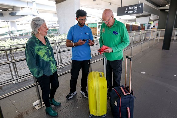Andrea and Ron Lewis talk to an Uber assistant at Melbourne Airport about their lost prepaid booking. 