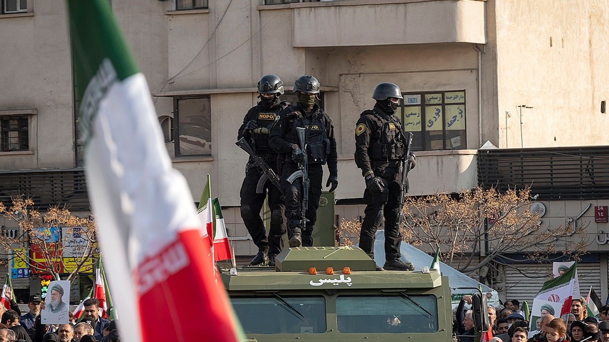 Ursula von der Leyen speaking at a podium with Iranian military rally in background