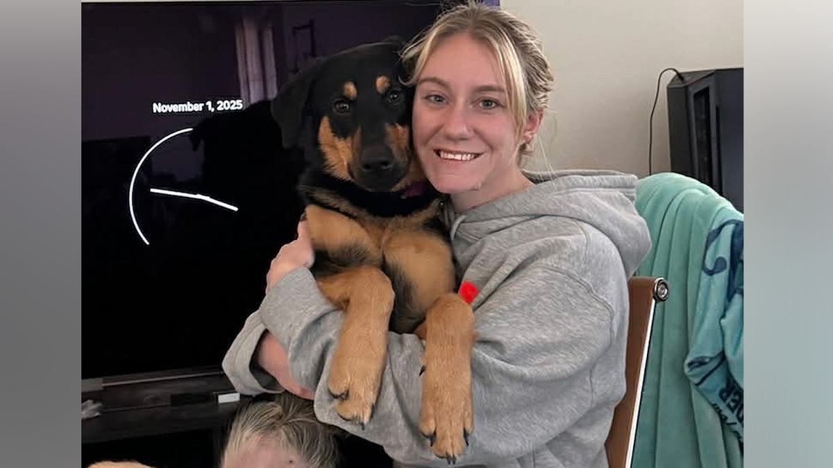 Ivy Unruh smiling and holding a dog in personal photo