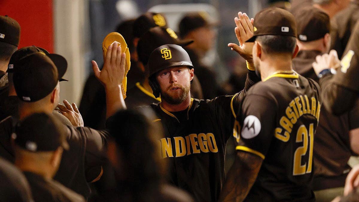 San Diego Padres' Jake Cronenworth scoring a run during a baseball game.