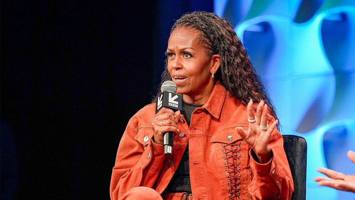 Michelle Obama speaking onstage during a podcast recording at Austin Convention Center