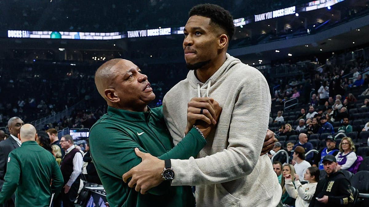 Milwaukee Bucks head coach Doc Rivers embracing Giannis Antetokounmpo before a basketball game.