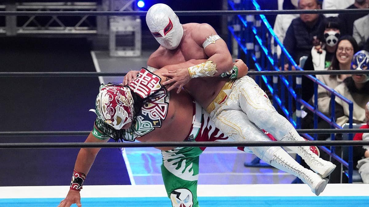 Mistico and Ultimo Guerrero wrestling in a ring at Yoyogi National Gymnasium in Tokyo