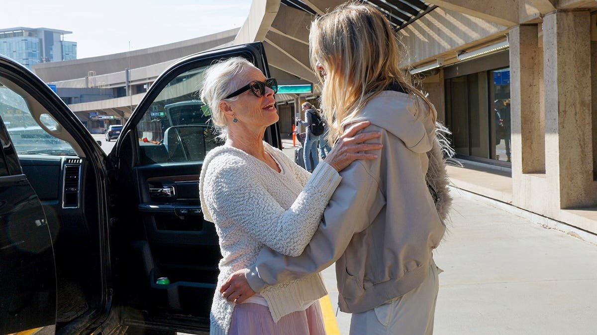 Mature mother and adult daughter saying goodbye at airport in Calgary