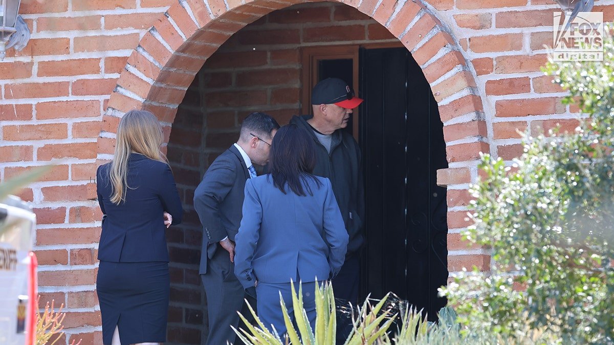 Investigators standing at the entrance of Nancy Guthrie's home in Tucson, Arizona