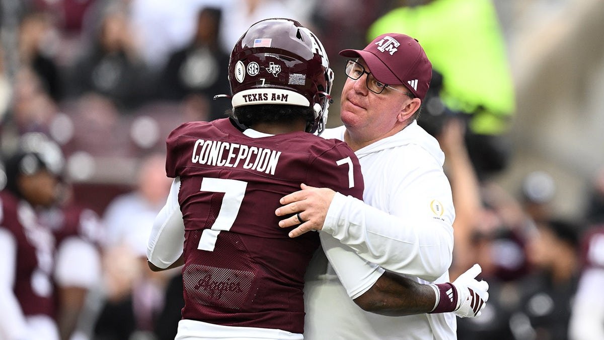 Texas A&M Aggies head coach Mike Elko hugging wide receiver KC Concepcion at Kyle Field