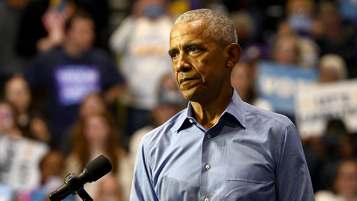 Former President Barack Obama speaking at a rally inside a college gymnasium
