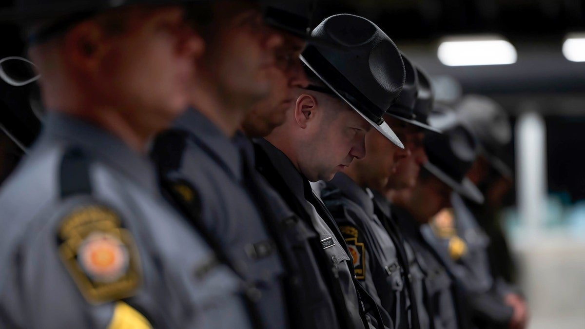 Pennsylvania State Police Trooper bowing his head during prayer at memorial service