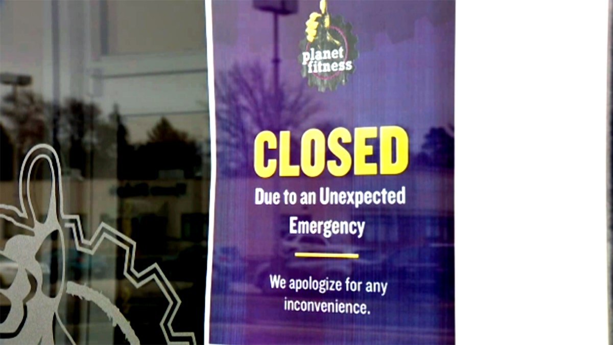a closed sign on the Planet Fitness window