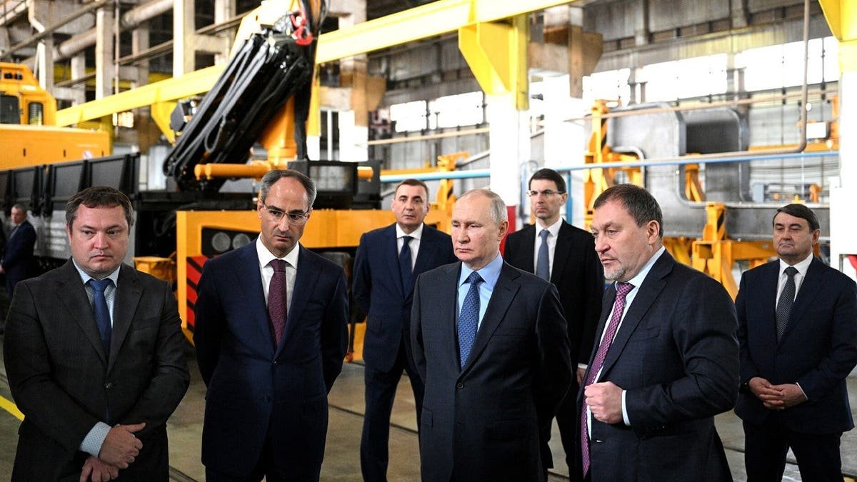 Russian President Vladimir Putin (C) inspects at facility of Tulazheldormash (Tula Railway Engineering Plant), manufacturer of heavy track equipment and equipment for the construction, renovation and maintenance of railway tracks, in Tula, Russia, on April 04, 2023.