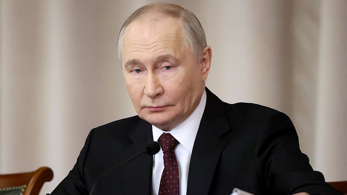 President Vladimir Putin speaking at a podium during Defender of the Fatherland Day event