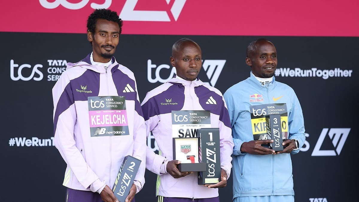 Sabastian Sawe standing with Yomif Kejelcha and Jacob Kiplimo at London Marathon presentation ceremony