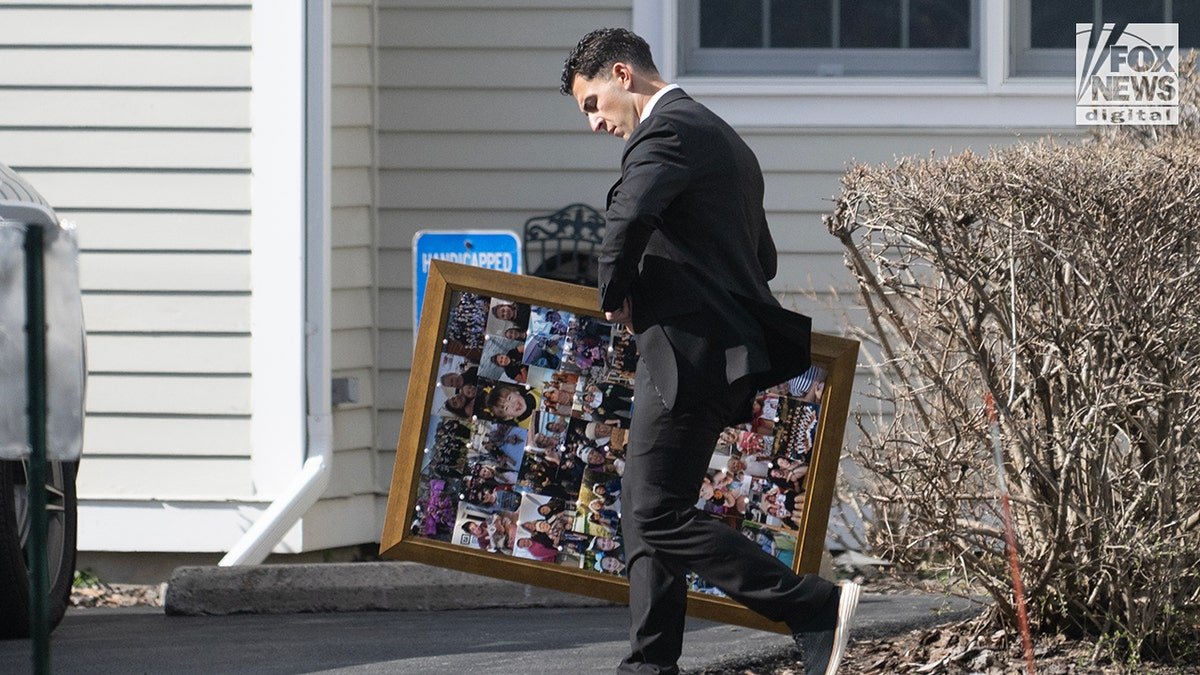 A man carries a framed collage of photos outside a memorial service for Sheridan Gorman at First Presbyterian Church of Yorktown, in Yorktown Heights, New York.