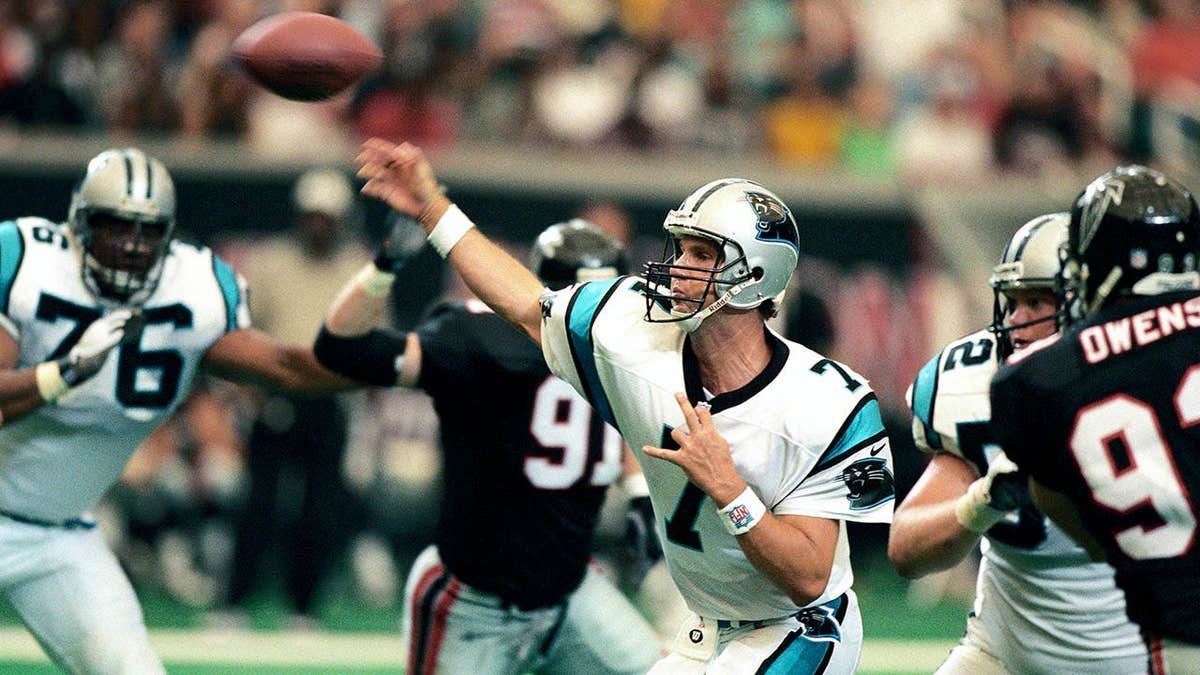 Steve Beuerlein throwing a football during a game against the Atlanta Falcons