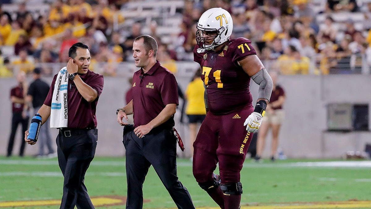 Arizona State Sun Devils offensive lineman Steven Miller walking off the field injured