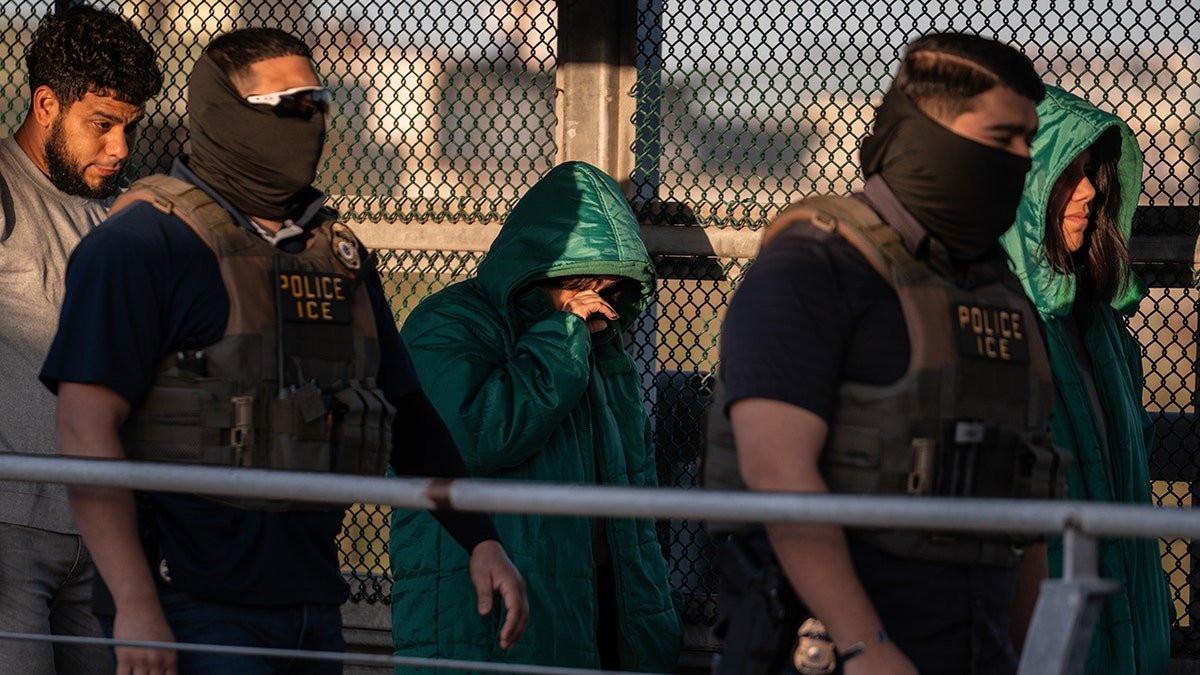 A group of undocumented migrants escorted by U.S. Immigration and Customs Enforcement agents across a bridge in McAllen, Texas