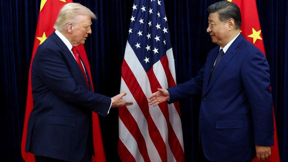 President Donald Trump shakes hands with Chinese President Xi Jinping in front of the American and Chinese flags.