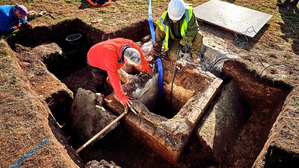 Excavators moving equipment into bunker hole