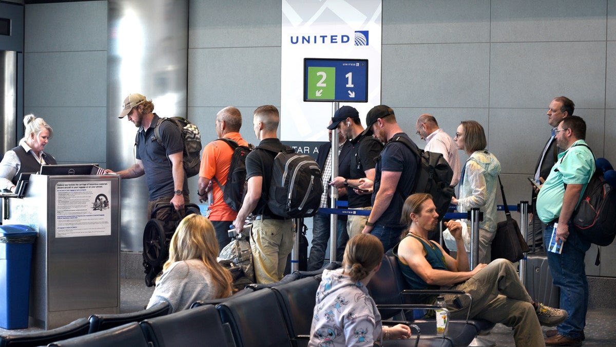 Passengers presenting boarding passes to a gate agent at Denver International Airport