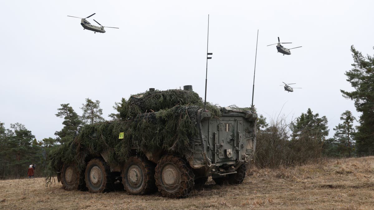 Boeing CH-47 Chinook helicopters flying over Lithuanian Vilkas infantry fighting vehicle near Hohenfels Germany
