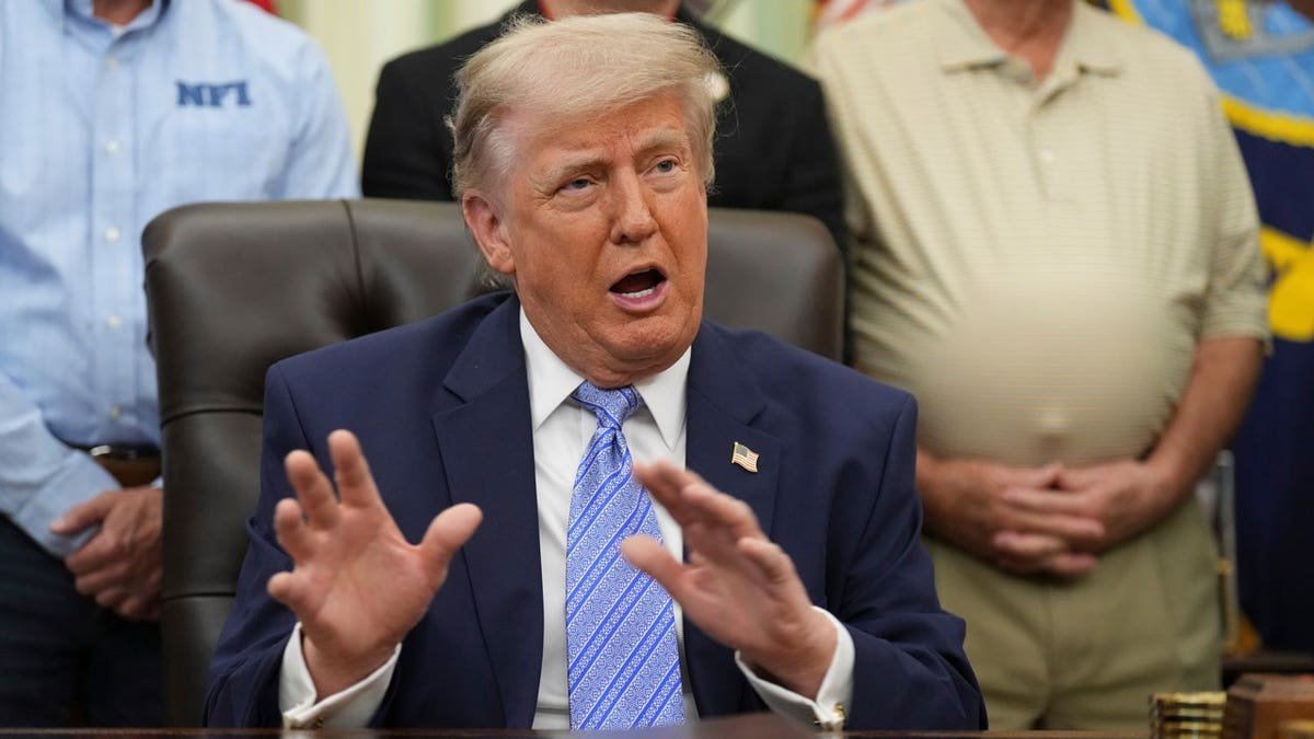 trump at resolute desk in oval office