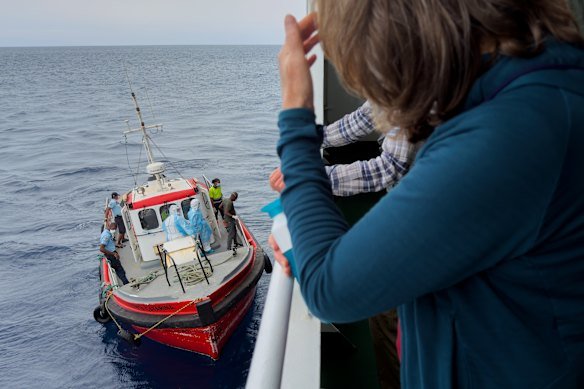 Passengers on the MV Hondius watch epidemiologists board the boat in Cape Verde.