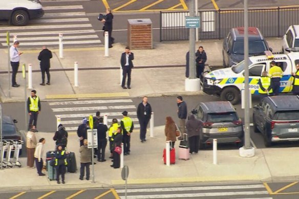 Travellers and security standing outside Avalon Airport after a bomb scare. 