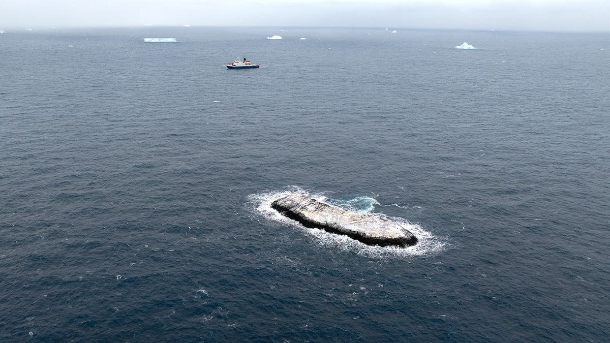 Aerial view of island with ship in the background