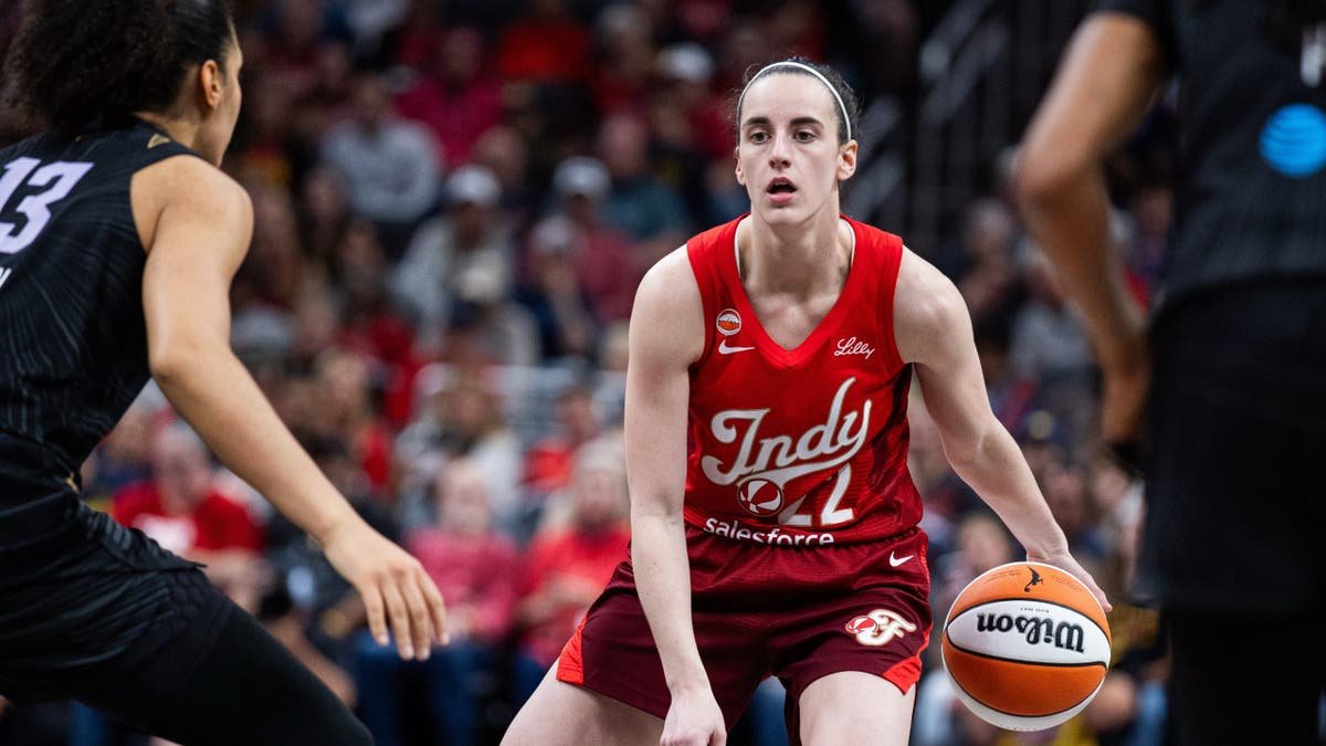 Indiana Fever guard Caitlin Clark dribbling basketball defended by Golden State Valkyries forward Janelle Salaun